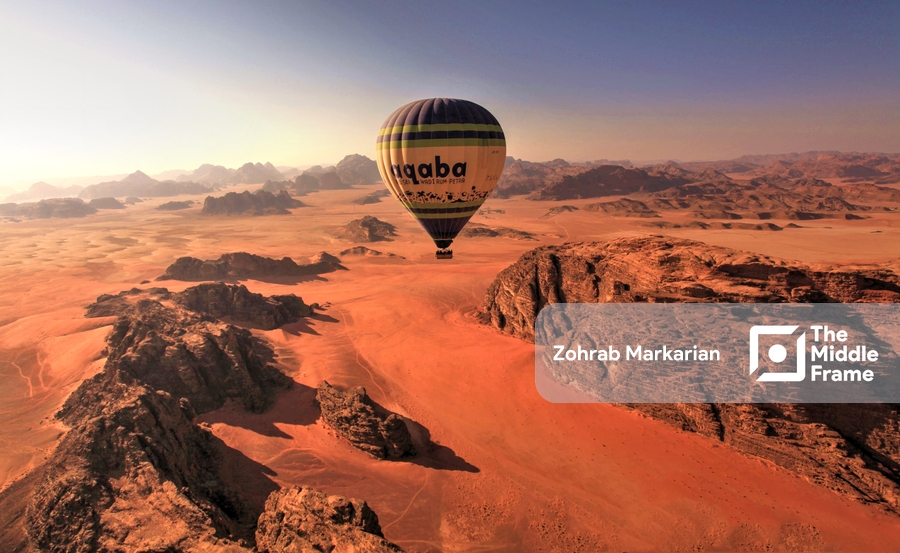 a hot air balloon flying over the desert