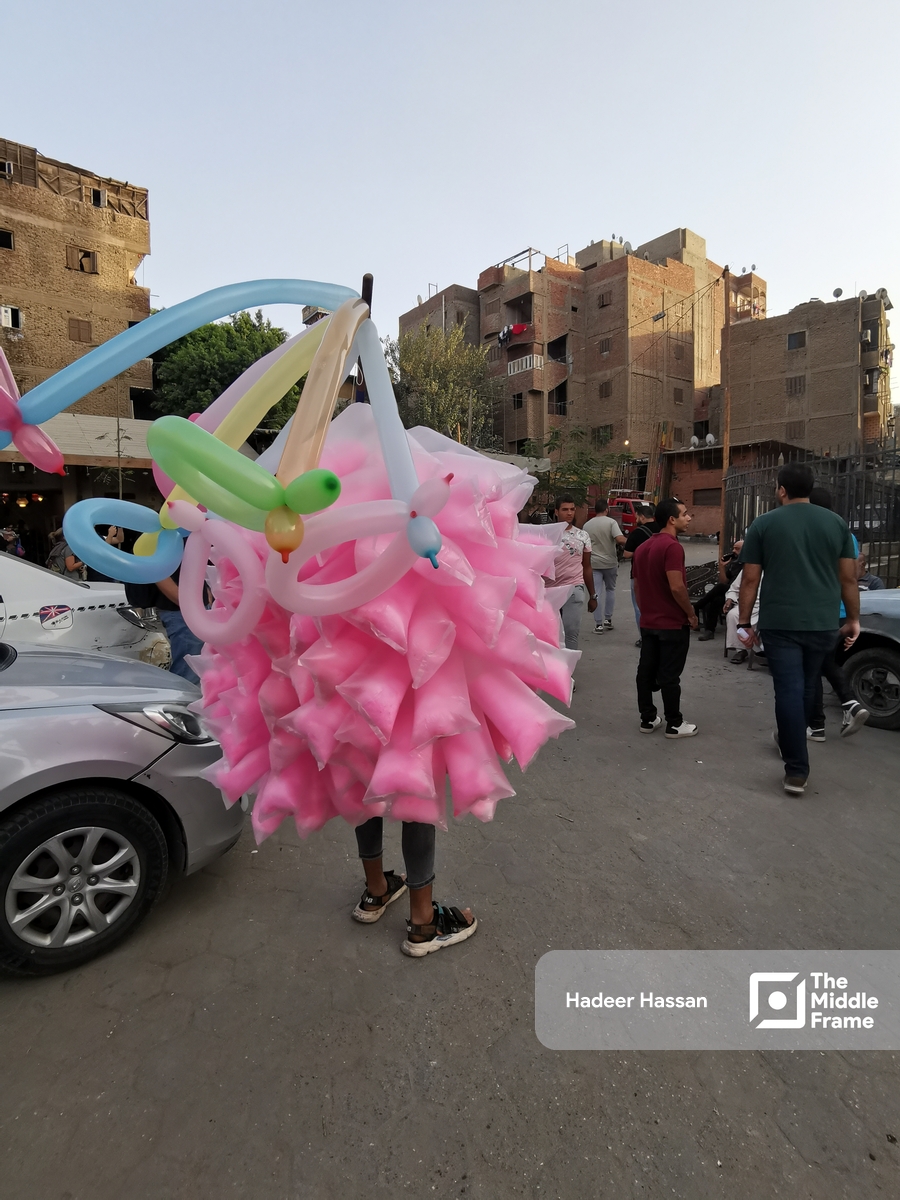 A man selling balloons and cotton candy