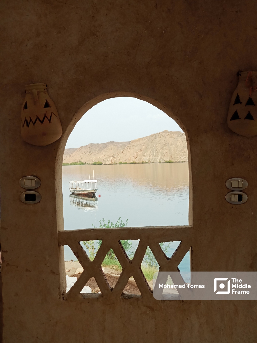 A view of a boat in the Nile river through an arched window in Egypt