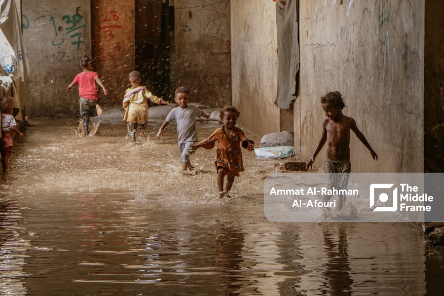 children play in a flooded street in the city