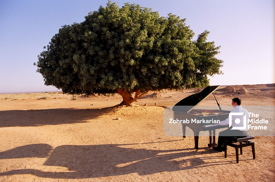 A man playing a piano in the desert