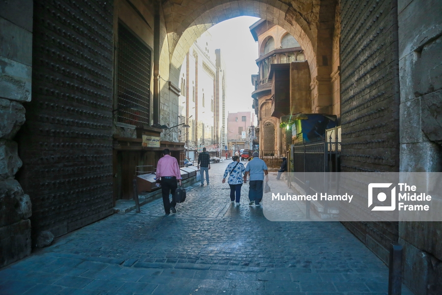 People walking down a narrow street in Old Cairo