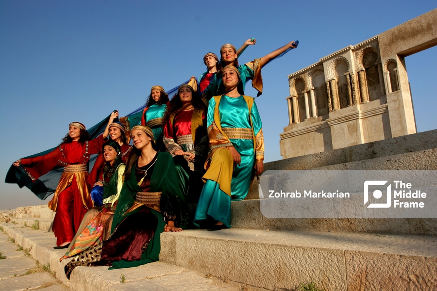 A group of young women in colorful dresses posing on steps