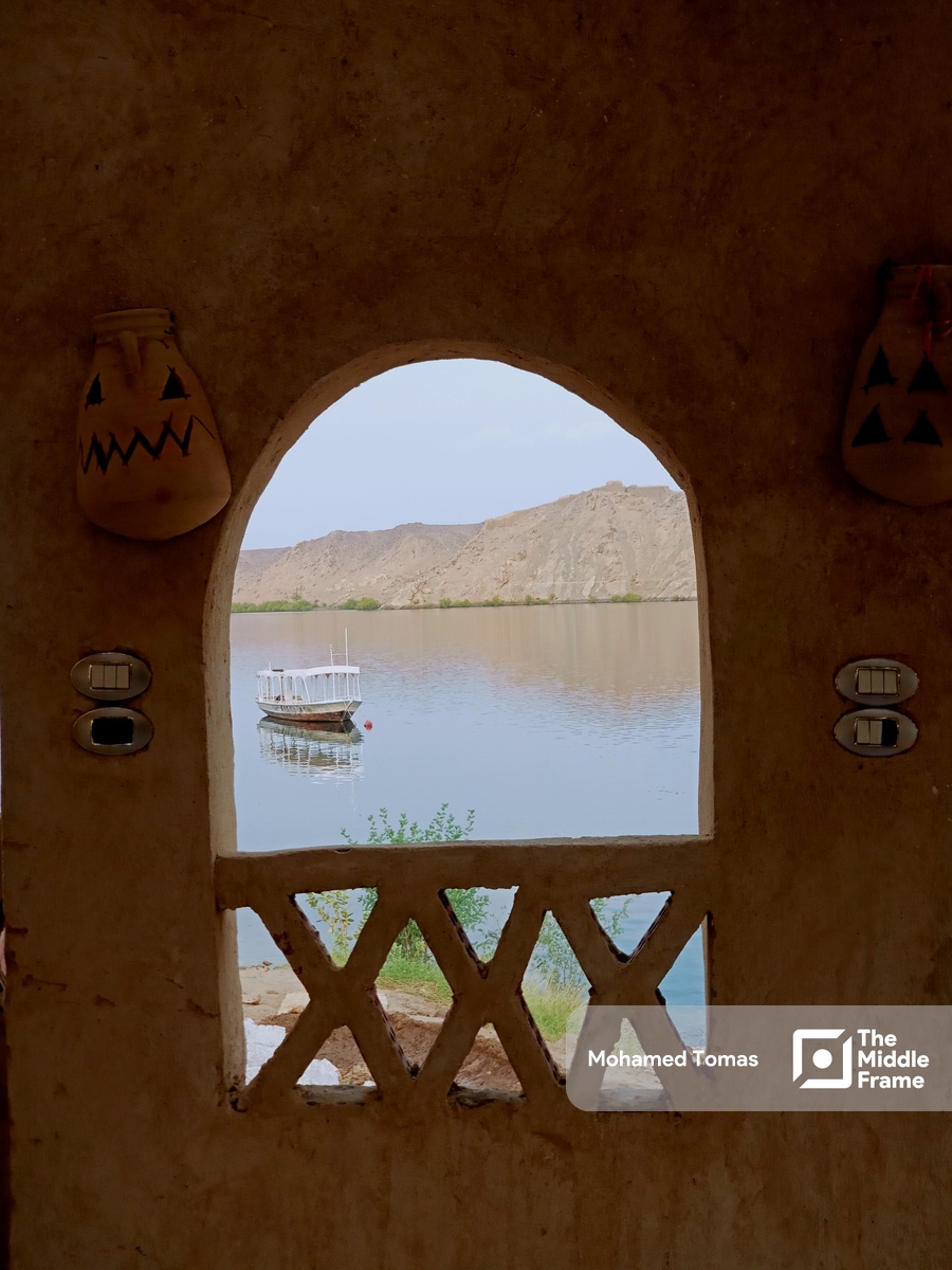 A view of a boat in the Nile river through an arched window in Egypt