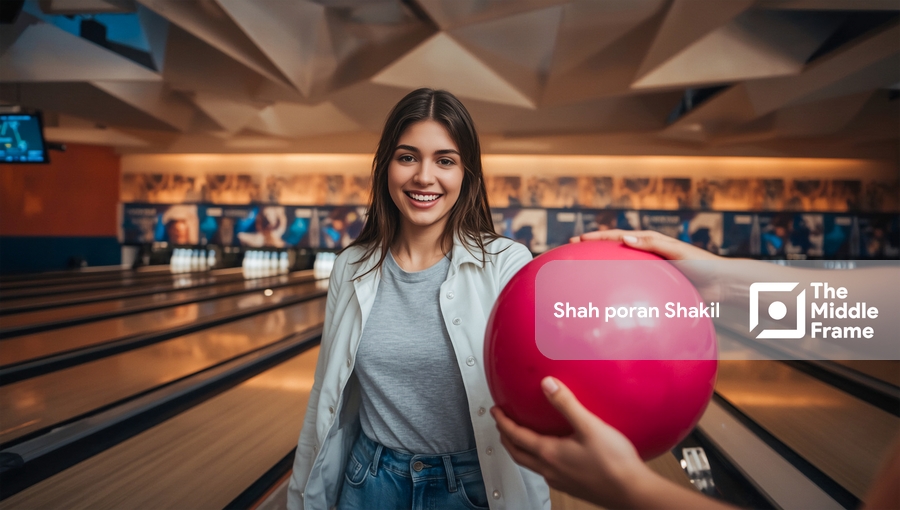 A woman holding a bowling ball in her hand