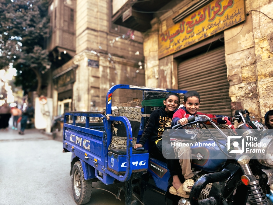 Children sitting on a parked motorcycle in the street.
