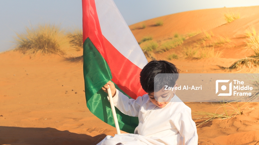 a boy in white clothes holding a flag