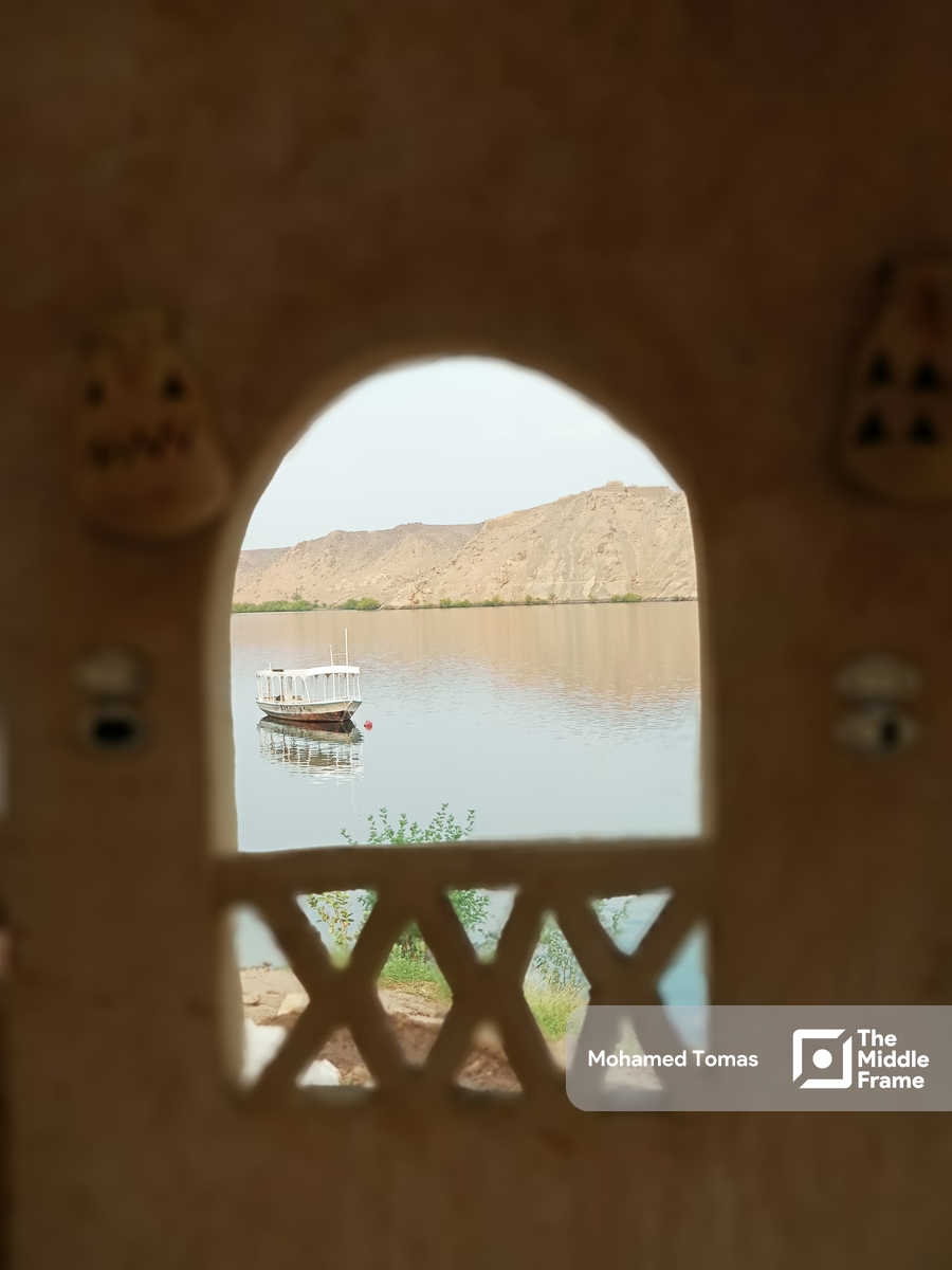 A view of a boat in the Nile river through an arched window in Egypt