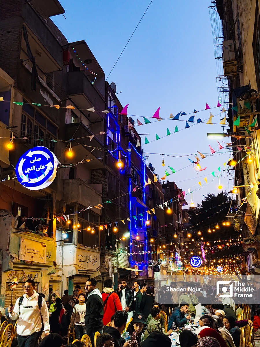 a crowded street with people sitting at tables
