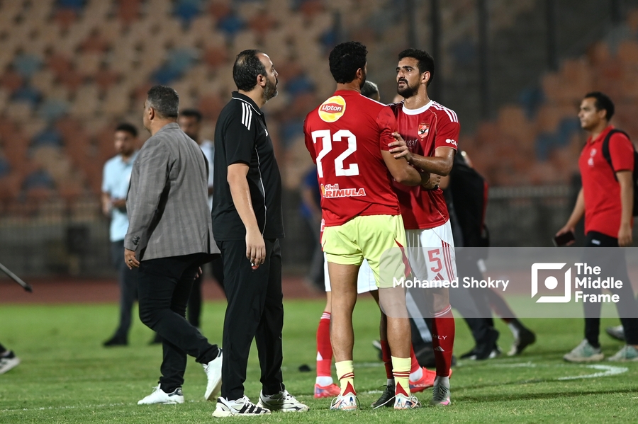 two men are standing on the field with one man in the middle