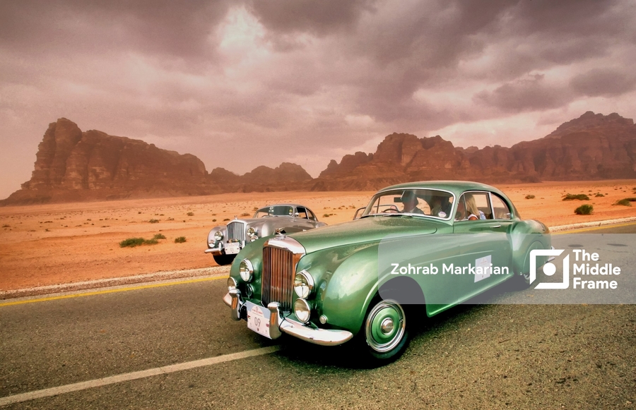 a green car driving down the road in the desert