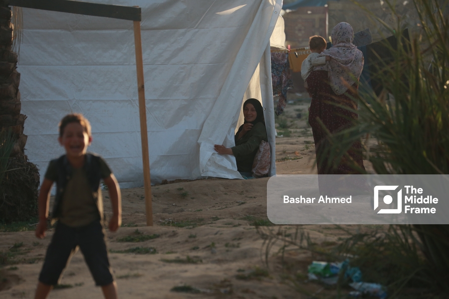 A Mother watching her son playing from the tent in the refugee camp ...