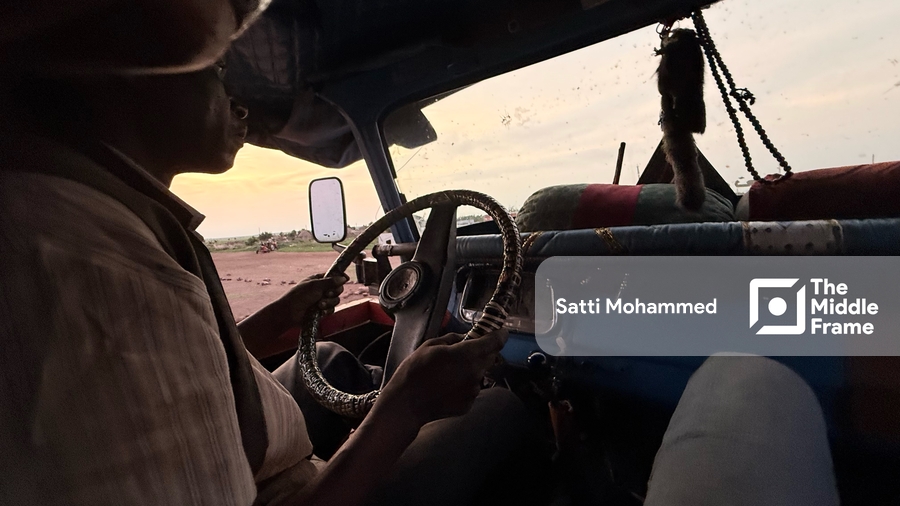 A man driving a car on a dirt road