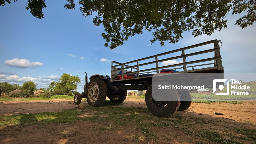 A tractor parked under a tree
