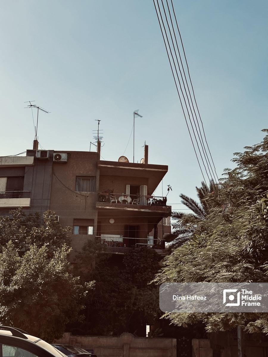 A street in a neighborhood in Cairo shows a building with balconies
