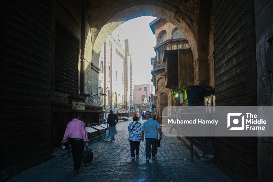 People walking down a narrow street in Old Cairo