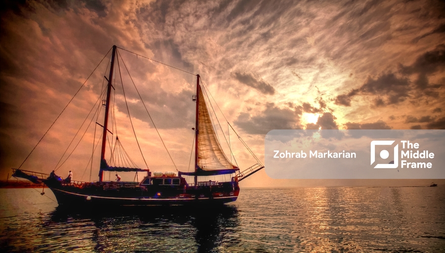 a sailer in the ocean at sunset