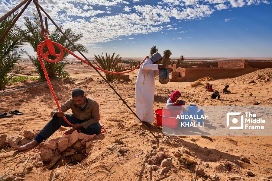Algerian men drawing water from desert wells