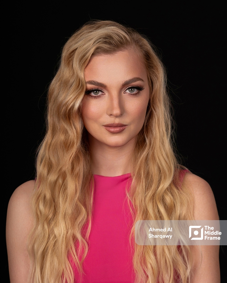 a woman with long blonde hair and a pink top