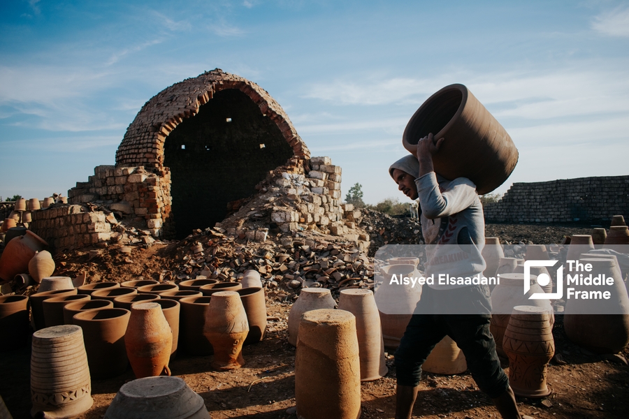 The potter between the worn walls of the old kiln.