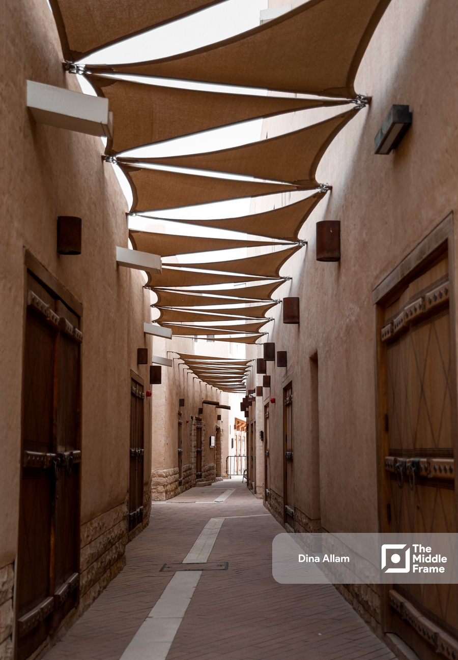 a narrow street with a wooden walkway and a canopy over it