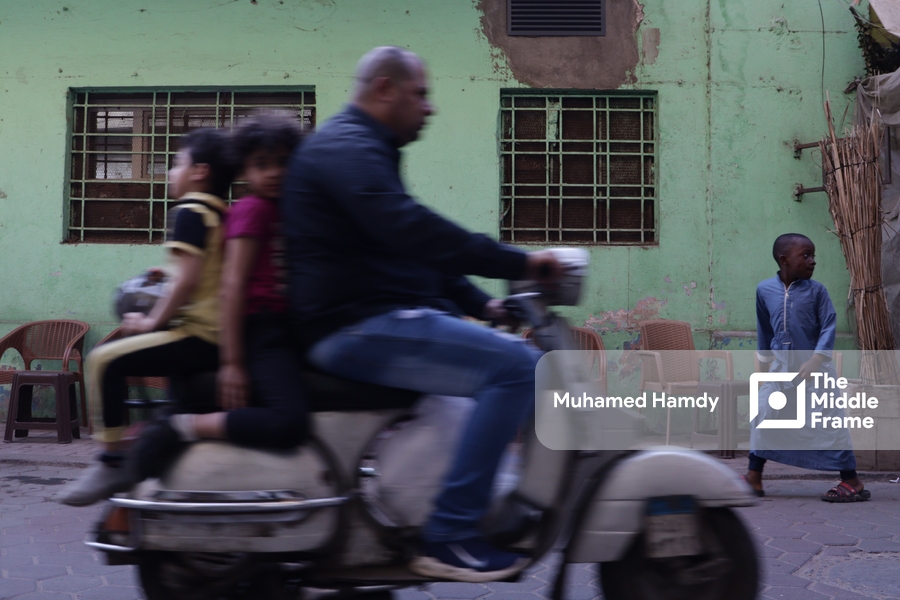 A man riding a vespa with his kids