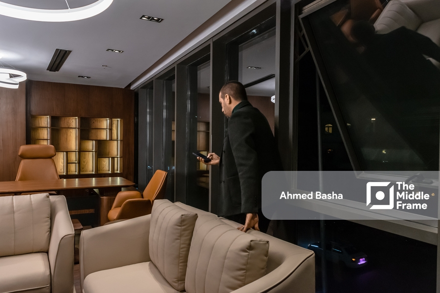 An Egyptian man looking at his phone in his office