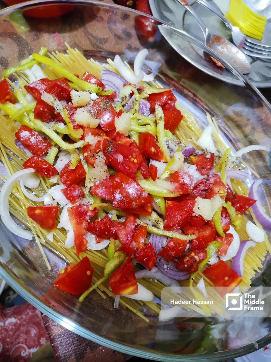 a plate of food with tomatoes, onions and pasta