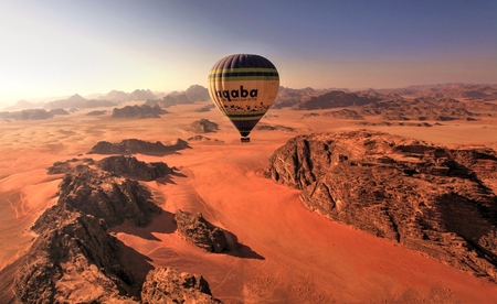 a hot air balloon flying over the desert