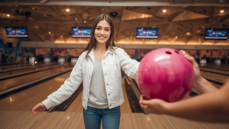A woman holding a bowling ball in her hand