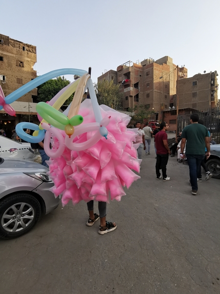 A man selling balloons and cotton candy