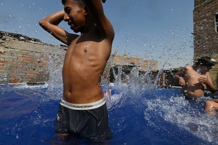 Children swimming in a pool in a traditional neighborhood in Egypt.