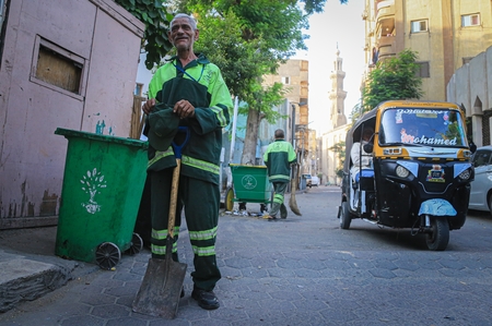 A cleaner standing in the street in Egypt