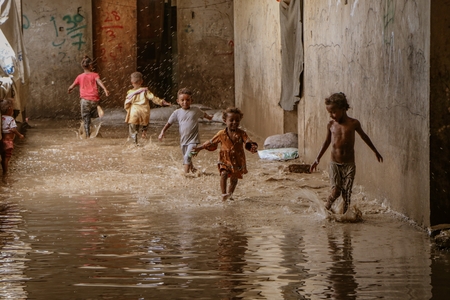 children play in a flooded street in the city
