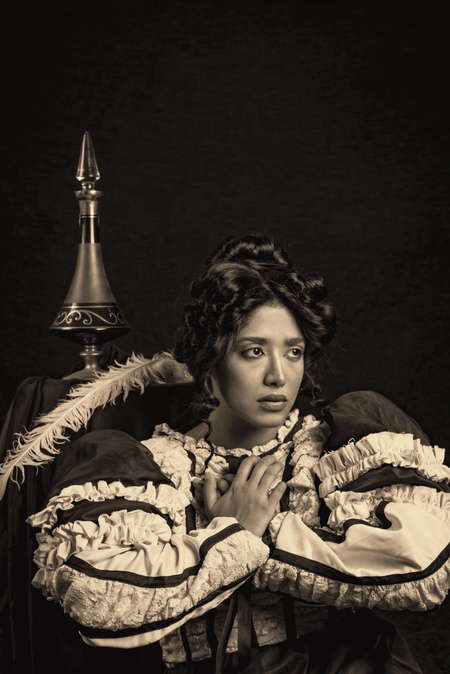 a woman in a black dress holding a baby