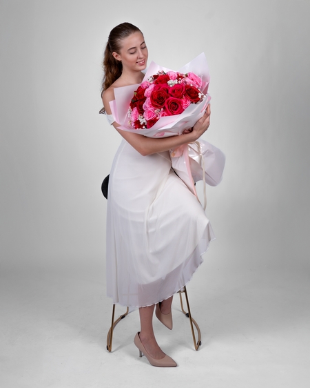 a little girl in a white dress holding a bouquet of flowers