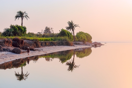 A little girl stands on the shore of Lake Qarun, Egypt.