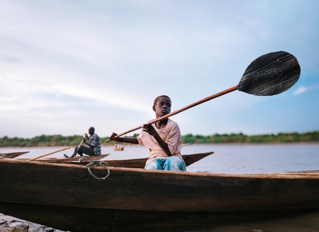 A child steering a boat on the Nile River in Sudan.