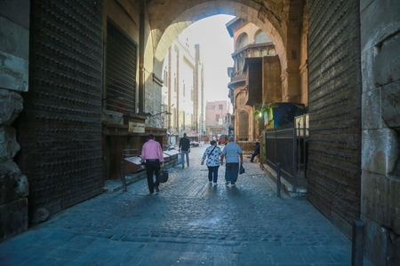 People walking down a narrow street in Old Cairo