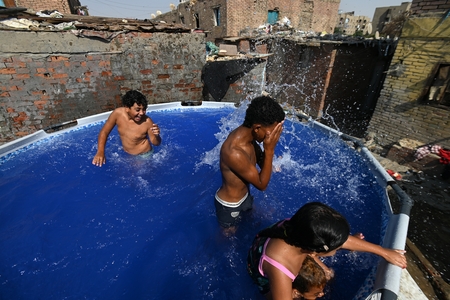 Children swimming in a pool in a traditional neighborhood in Egypt.
