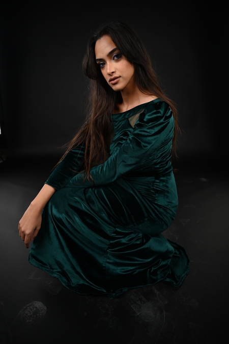 A woman in a green dress sitting on the floor