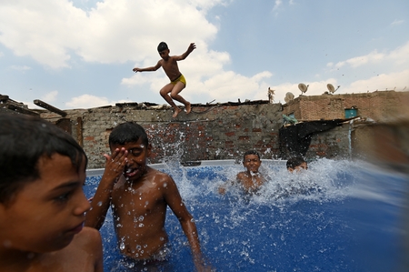 Children swimming in a pool in a traditional neighborhood in Egypt.