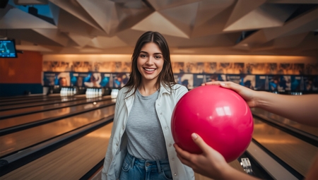 A woman holding a bowling ball in her hand