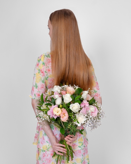 a woman with long hair holding a bouquet of flowers