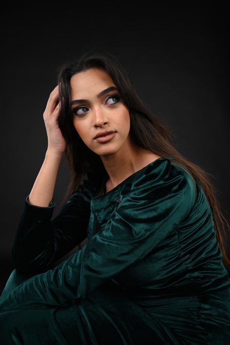 A woman in a green dress sitting on the floor