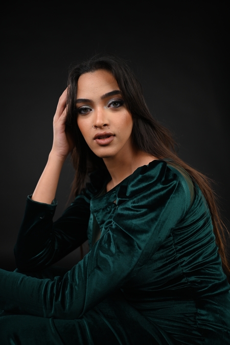 A woman in a green dress sitting on the floor