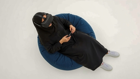 A woman sitting and playing video games remotely