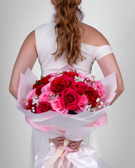 a woman in a white dress holding a bouquet of roses