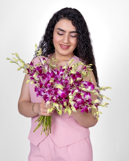 a woman holding a bouquet of orchids