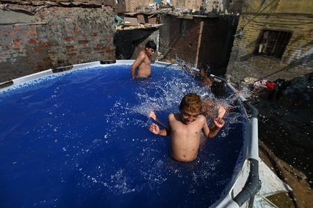 Children swimming in a pool in a traditional neighborhood in Egypt.